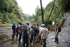 足元の水も厭わず、解説に集中